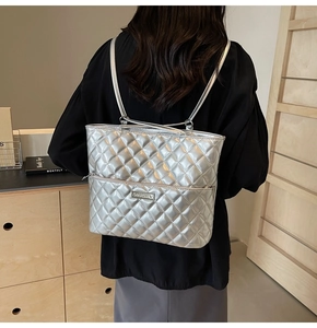 Detail of silver quilted PU backpack with metallic finish and metal logo plate