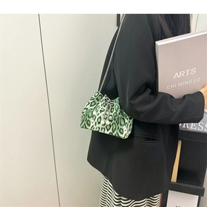 Detailed view of mini green leopard print bucket bag with metal chain and large pearls