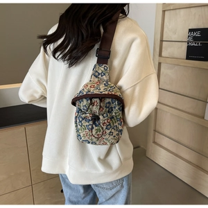 Detail view of the floral jacquard fabric and drawstring closure on the crossbody bag