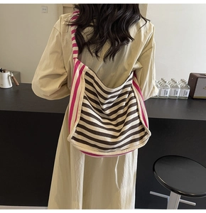 Detail view of large striped canvas tote bag with bold fuchsia accents and shoulder strap