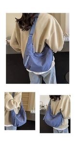 Detailed view of blue canvas half-moon bag with adjustable straps and woven zipper detail