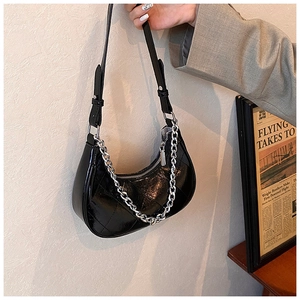 Détail du sac croissant noir en similicuir matelassé avec chaîne argentée et sangle