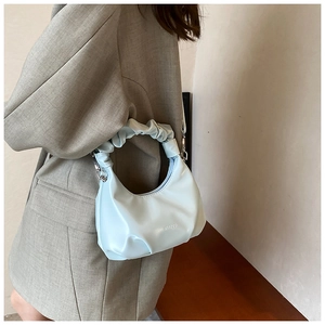 Detail shot of light blue ruched PU leather cloud bag with silver zipper and brand logo
