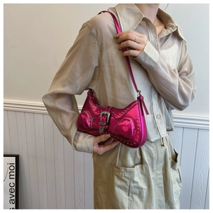 Detail of rose red metallic PU handbag featuring silver studs and punk metal buckles
