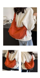 Detail of nylon crossbody dumpling bag with woven zipper pull and adjustable strap