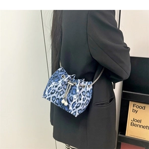 Close-up of blue leopard print drawstring bag with silver chain and pearl accents