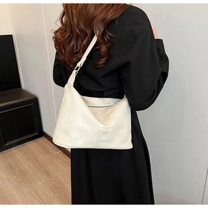Chic beige PU leather crossbody bag with geometric stitching shown on a model