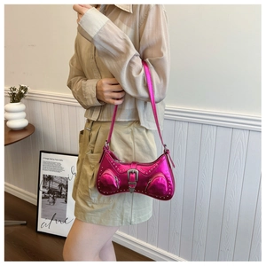 Detail of rose pink metallic Y2K shoulder bag featuring silver rivets and vintage buckle