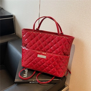 Classic red quilted patent leather handbag with a metallic plaque and long shoulder strap