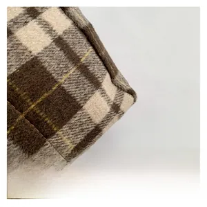 Gros plan sur un tissu en laine à carreaux marron et blanc avec texture pelucheuse