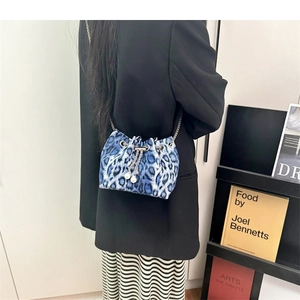 Detail of blue leopard print bucket bag with silver chain and white pearl charms