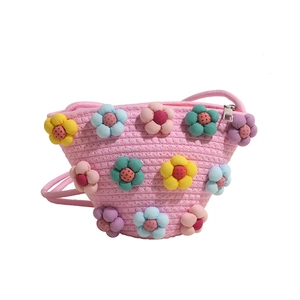 Pink woven bucket bag with colorful plush flowers and crossbody strap for women