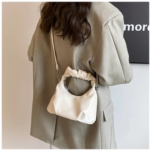 Detail of a creamy white PU leather crossbody bag with a ruched handle and embossed logo