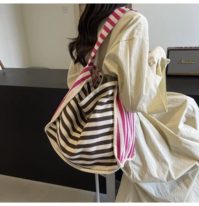 Detail view of large canvas tote bag with pink and brown stripe contrast on shoulder