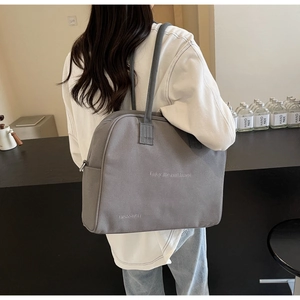 Detailed side view of grey large capacity canvas tote bag with Enjoy life and travel print