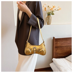 Close-up of golden PU leather handbag with silver rivets and western-style buckle details