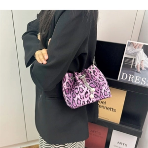 Detail of purple leopard print bucket bag with chain strap and pearl drawstring accents