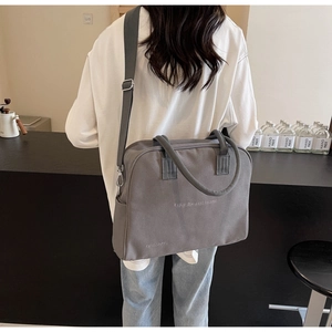 Detail of gray canvas tote with Enjoy Life and Travel text and adjustable strap