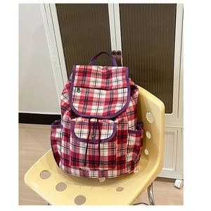 Vintage nylon plaid backpack with red and white patterns and purple piping on yellow chair