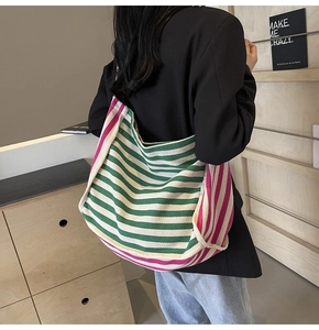 Detailed view of the large capacity canvas tote bag with pink and green stripes on a model