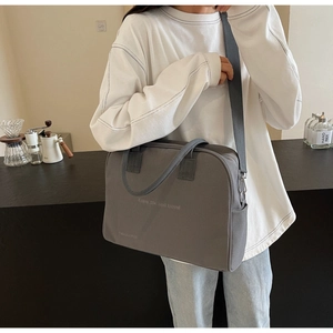 Detail view of a grey canvas crossbody bag with Enjoy Life print and adjustable shoulder strap