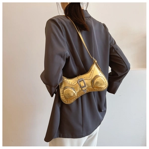 Detail of a metallic gold PU leather shoulder bag with punk rivets and wave design