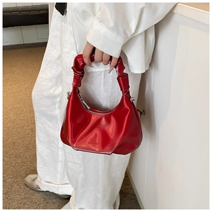 Detail of red PU hobo bag featuring glossy finish and unique ruched handle design
