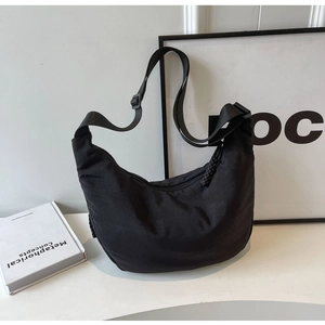 Detail of black nylon hobo bag with adjustable wide strap and woven rope zipper pull