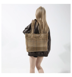 Détail d'un grand sac cabas en laine à carreaux avec un motif marron et beige texturé