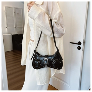 Detail of black glossy hobo bag with silver studs and vintage western buckle