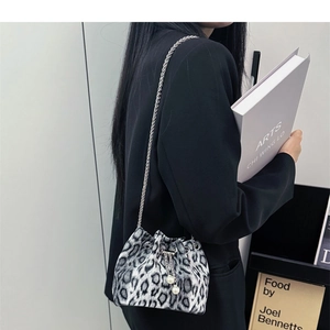 Detail of leopard print bucket bag with silver chain strap and pearl charm accent