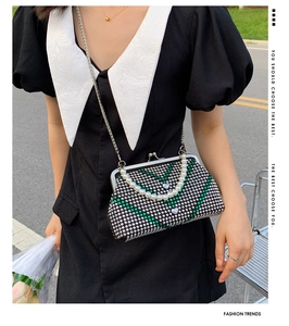 Detail of crossbody bag with green rhinestones, pearl handle, and heart-shaped buckle