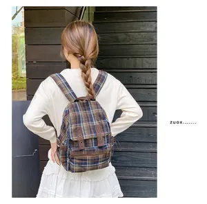 Outdoor back view of a plaid wool backpack with leather straps on a casual model