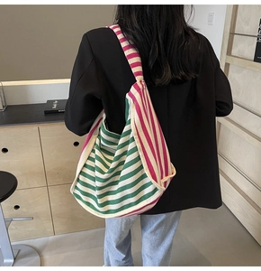 Detailed close-up showing vibrant green and pink diagonal striped canvas texture on the tote