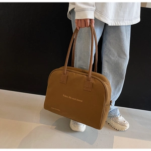 Detail of a brown canvas tote bag with Enjoy life and travel text print