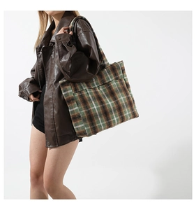 Détail du grand sac cabas en laine mélangée à carreaux verts et marrons avec poche frontale