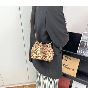 Detail of leopard print bucket bag with metal chain strap and white pearl drawstring charms
