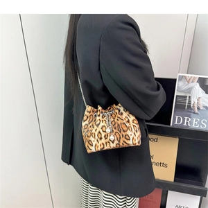 Detail of leopard print bucket bag featuring pearl charms and a silver chain strap