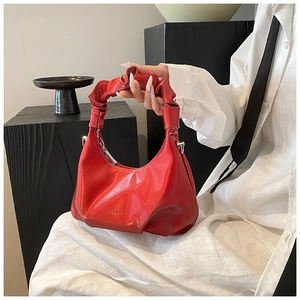 Detail view of red PU leather handbag featuring elegant ruched handle and embossed logo