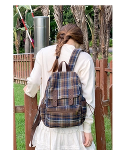 Outdoor shot of a vintage plaid backpack featuring classic blue and brown check patterns