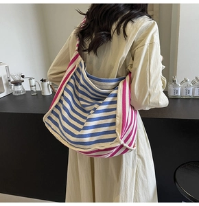 Detailed texture of blue and white striped canvas tote with rose red handles