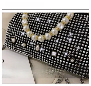 Detailed view of luxury evening bag with sparkling rhinestones and heart-shaped pearls