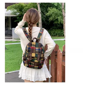 Detail of colorful plaid tweed backpack featuring brown leather flap and retro buckle