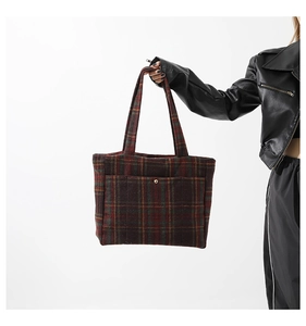 Gros plan du sac cabas vintage en laine à carreaux avec texture et boucle dorée