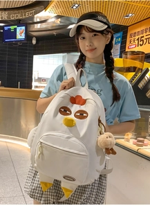 Detail of white cartoon chicken nylon backpack featuring plush charm and branded logo