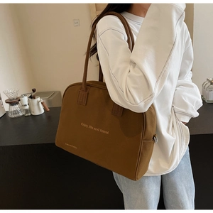 Close-up of caramel brown canvas tote bag with Enjoy Life slogan and sturdy shoulder strap