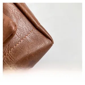 Close-up of caramel PU leather texture and premium stitching on the stylish women handbag