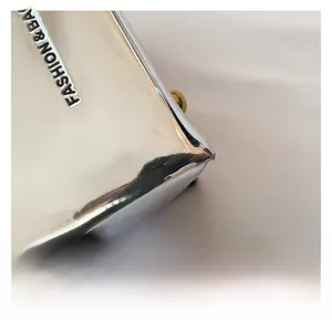 Dettaglio borsa a secchiello argento metallizzato con scritte in rilievo e catena moda