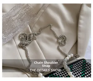 Detail showing crystal rhinestone cross-body bag with pearl handle and chain strap