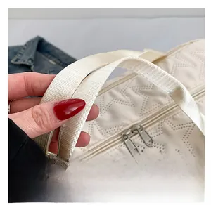 Close-up of star-quilted fabric texture with dual zippers and woven handle straps